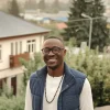 Homme souriant devant une maison à thiès Homme souriant devant une maison à Thiès – Opportunité immobilière au Sénégal